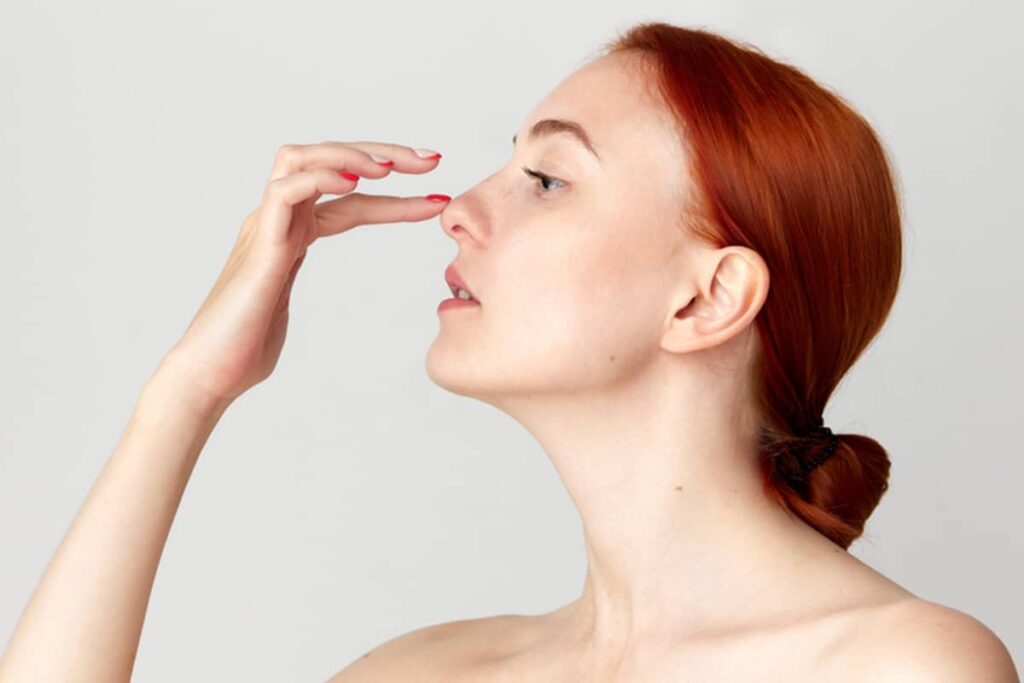 Frontal view of a woman with a rounded nasal tip, highlighting the area where patients often seek more definition and a narrower appearance through rhinoplasty.